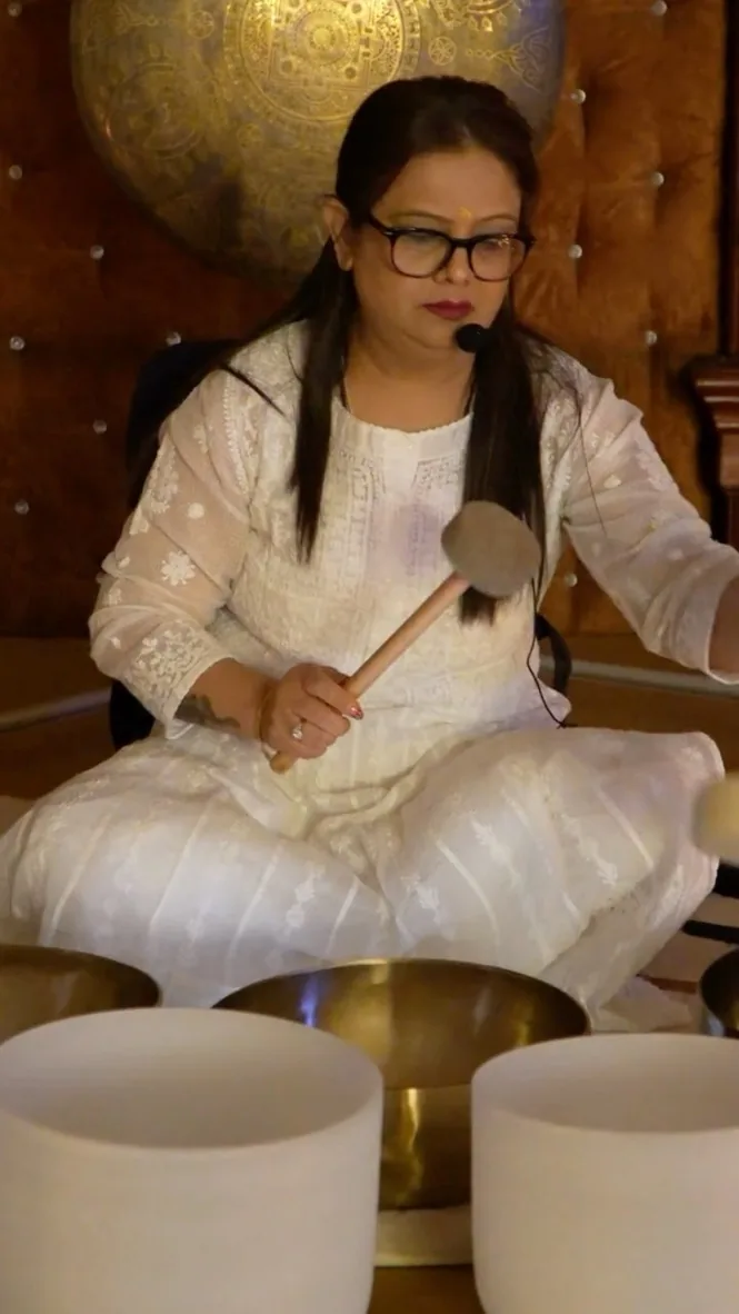 Pooja seated among her singing bowls