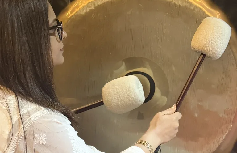 Pooja playing a gong